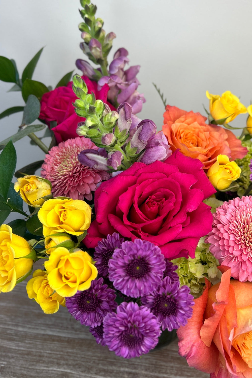 Small bouquet of roses, daisies, in pinks, lavenders, lime greens and corals for fun bouquet with pops of color