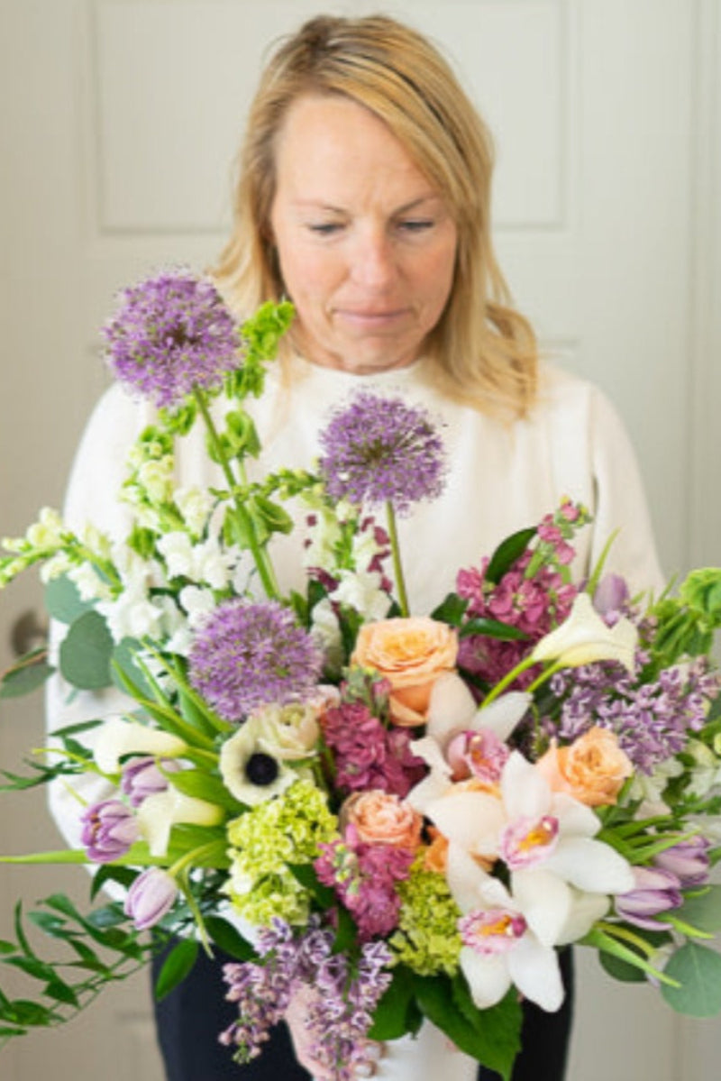 a designer choice bouquet of flowers being held by the shop owner