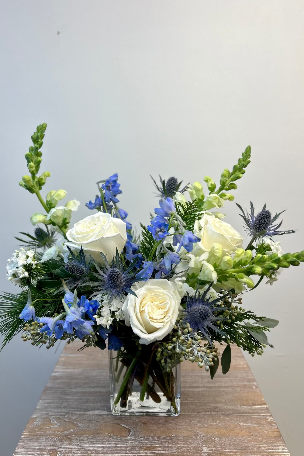 Arctic Whisper bouquet with white and light blue flowers and evergreens