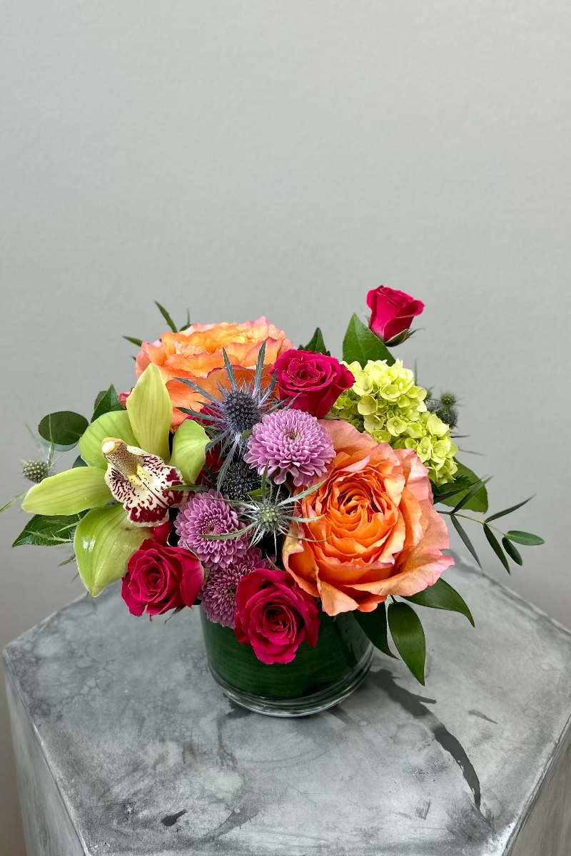 Close-up of petite Bloomfetti bouquet with jewel-toned blooms in glass vase