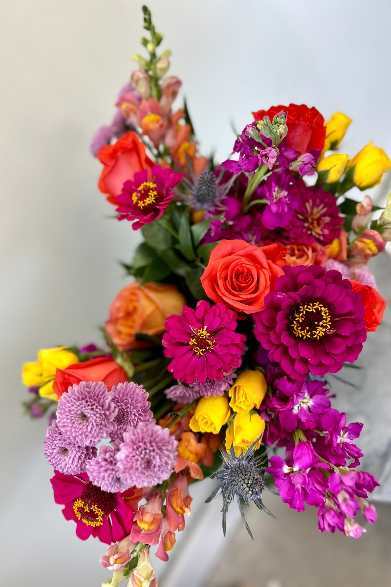 Close-up of Bloomfetti bouquet showing vibrant jewel-toned blooms and textured greenery