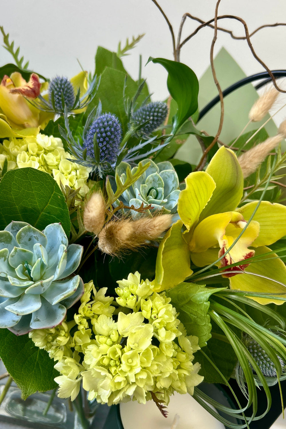 A woodsy Father’s Day bouquet with succulents, branches, thistle, and textured foliage close-up for delivery in Castle Pines 