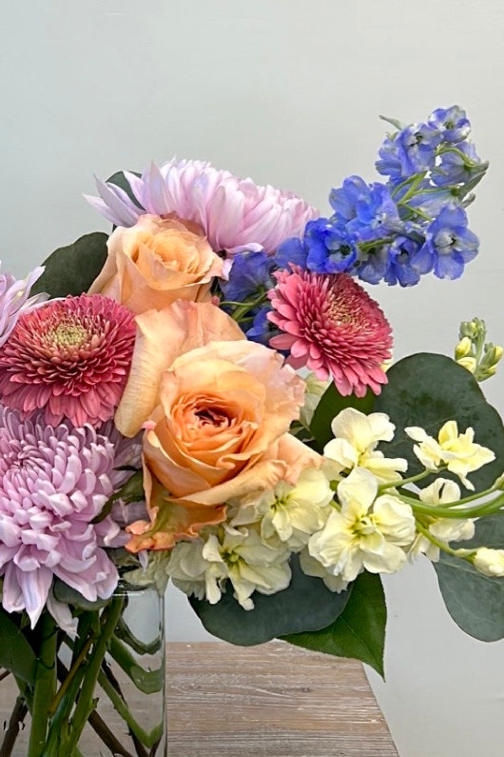pastel bouquet with roses, gerbera daisies, delphinium, stock and cremones