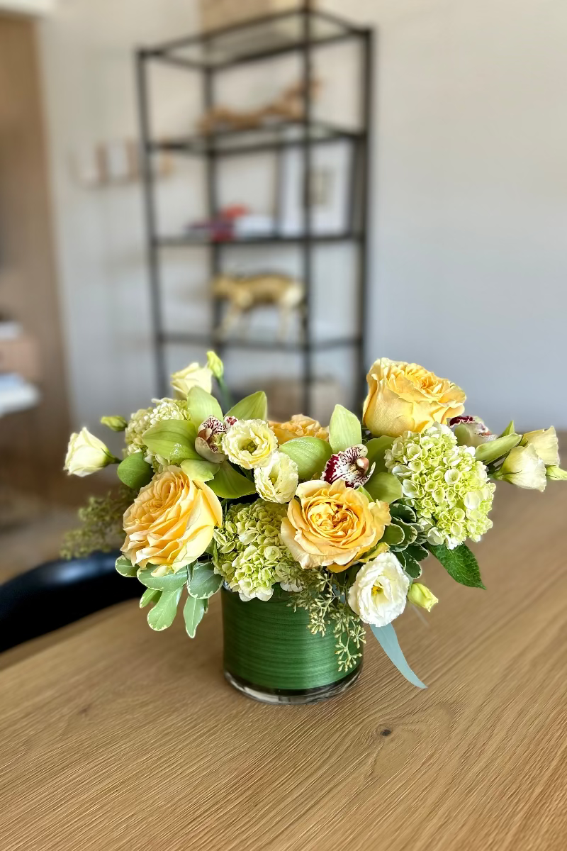 Lemon &amp; Light signature bouquet displayed on a table with natural light highlighting soft yellow and green tones