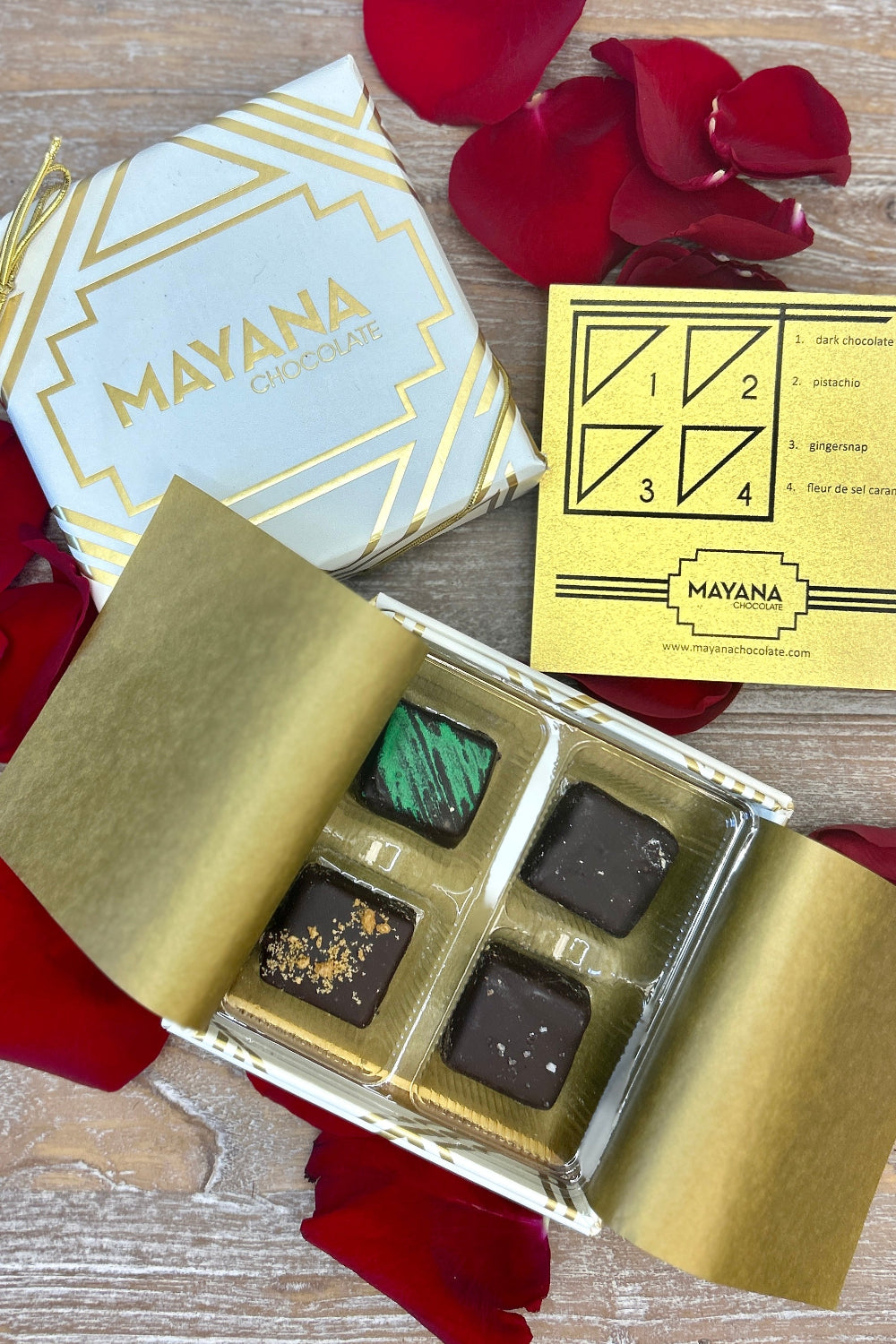 Mayana Chocolates 4‑Piece Luxury Collection in an ivory and gold box featuring four artisan bonbons.