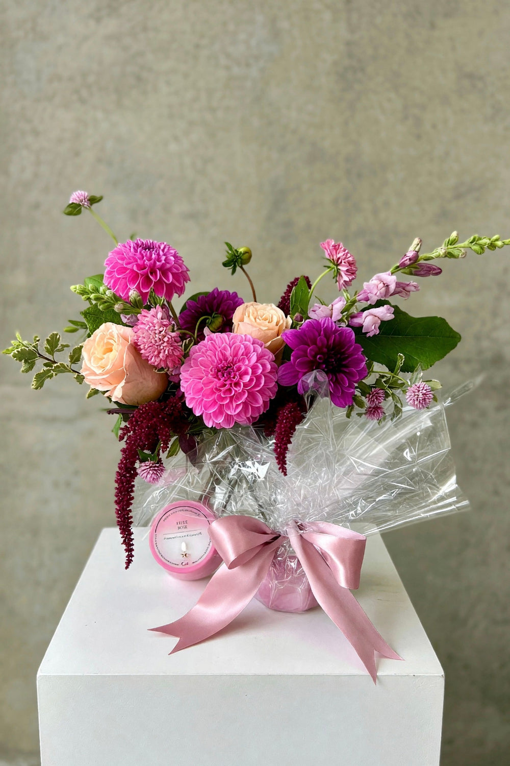 Mulberry Meadow Set featuring a pink and purple seasonal bouquet with burgundy accents alongside an Apple Rose scented candle"
