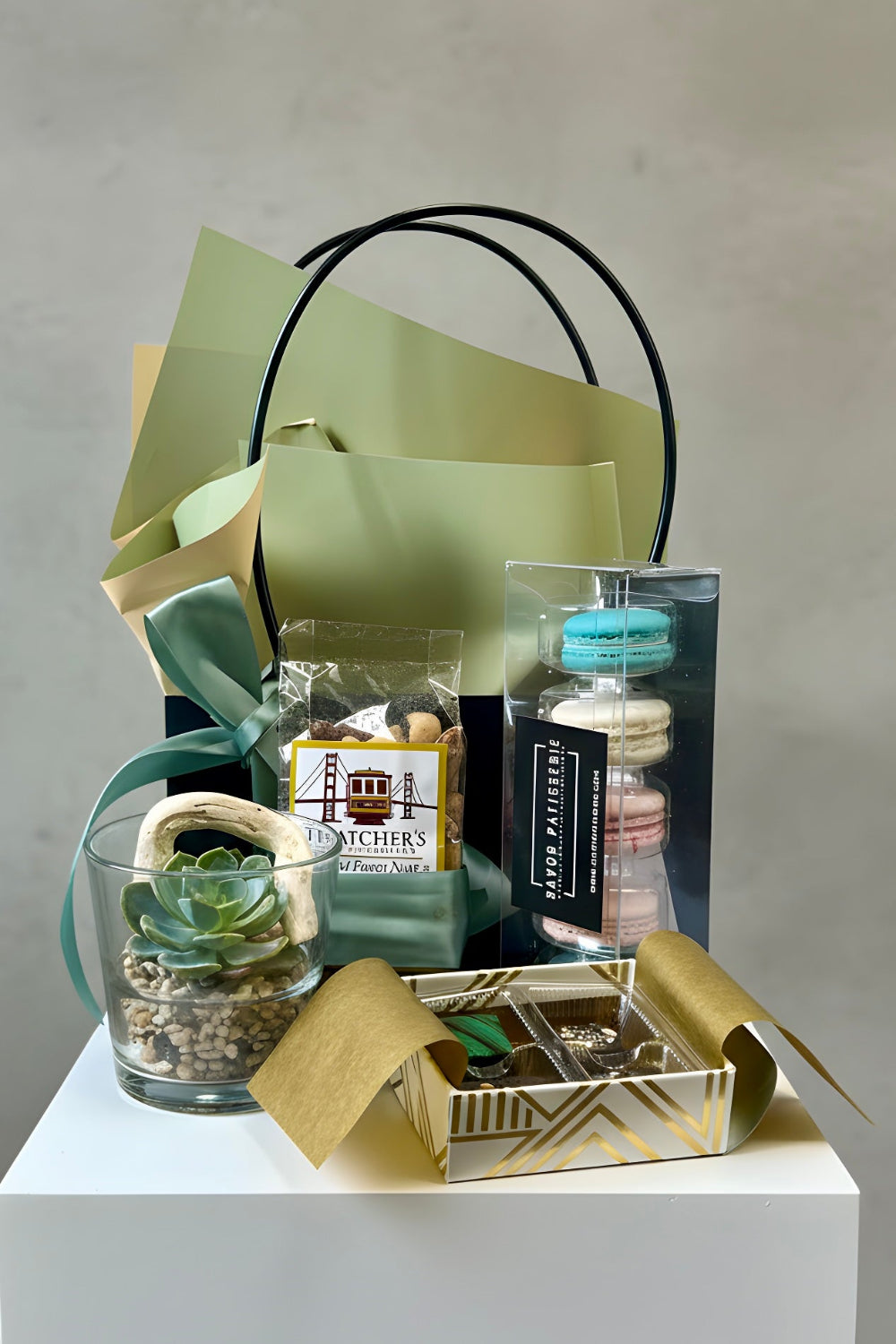 A Father’s Day gift set featuring a small succulent, artisan chocolates, unicorn macarons, and premium mixed nuts arranged in a premium gift bag.