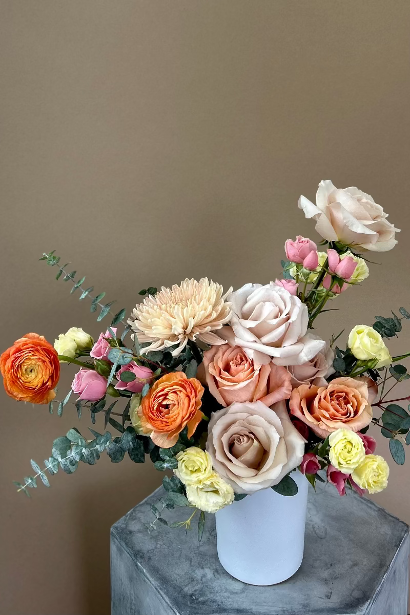 Pale Drift signature bouquet displayed on a table with natural light highlighting soft colors and airy textures