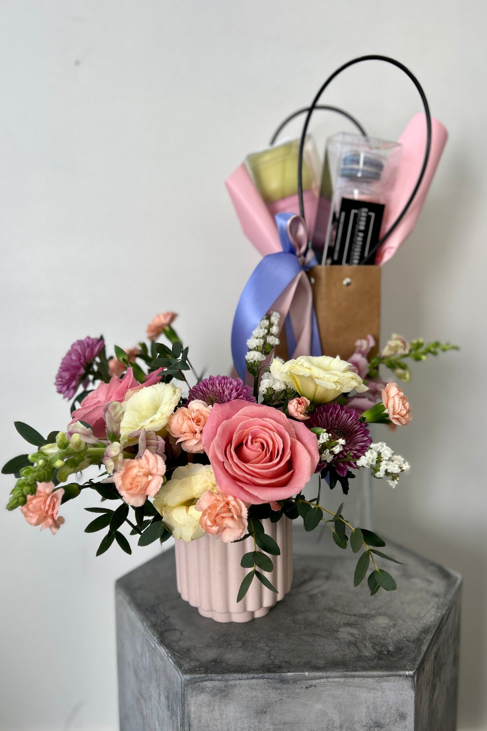 Spring gift set featuring pastel flowers, unicorn macarons, and a Pretty in Pastel candle set of three