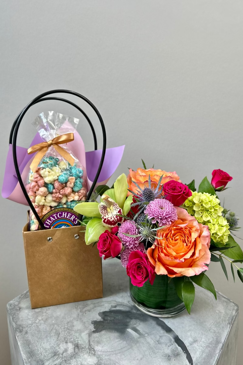 Pop &amp; Petals gift set displayed on a table with bouquet and gourmet popcorn ready for gifting