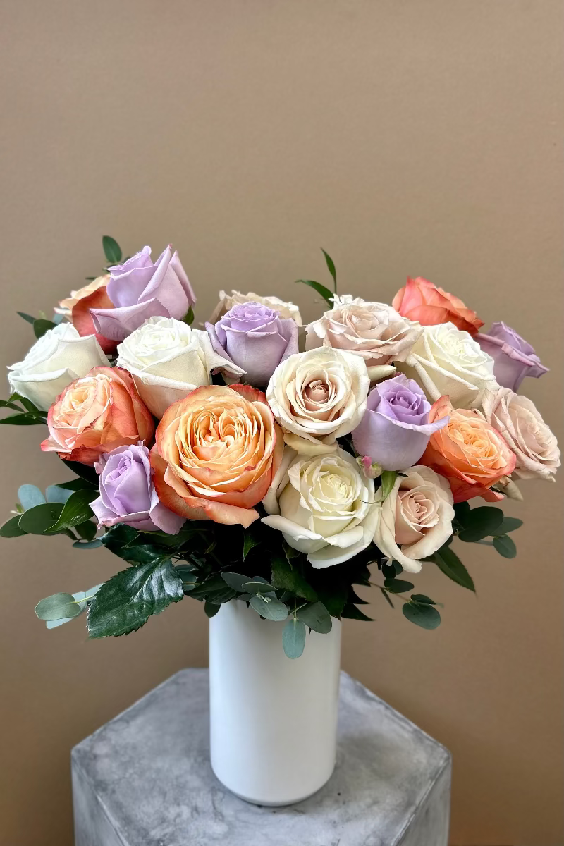 Rose Crème signature bouquet with lavender, light pink, white, and café latte roses in a matte white vase

