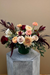 Rosé Ember signature bouquet with burgundy safari sunset, blush roses, peach ranunculus, cremones, and eucalyptus in a loose, airy design