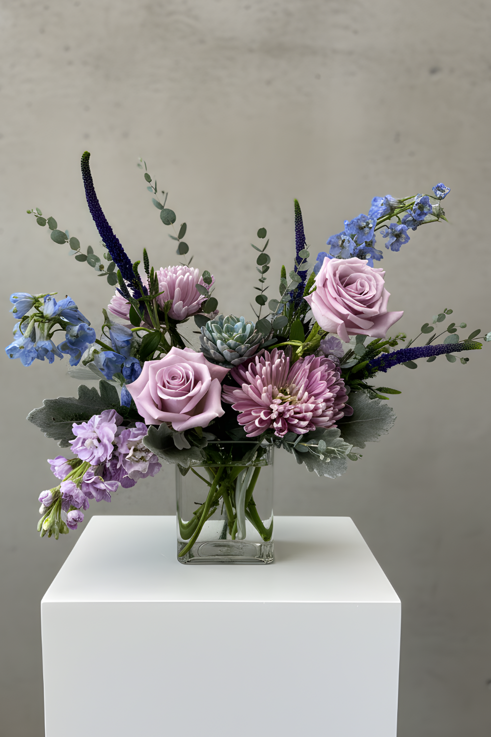 Petite Sanctuary Pastels bouquet with soft lavender, blue, sage green and purple flowers arranged in a garden‑style design 