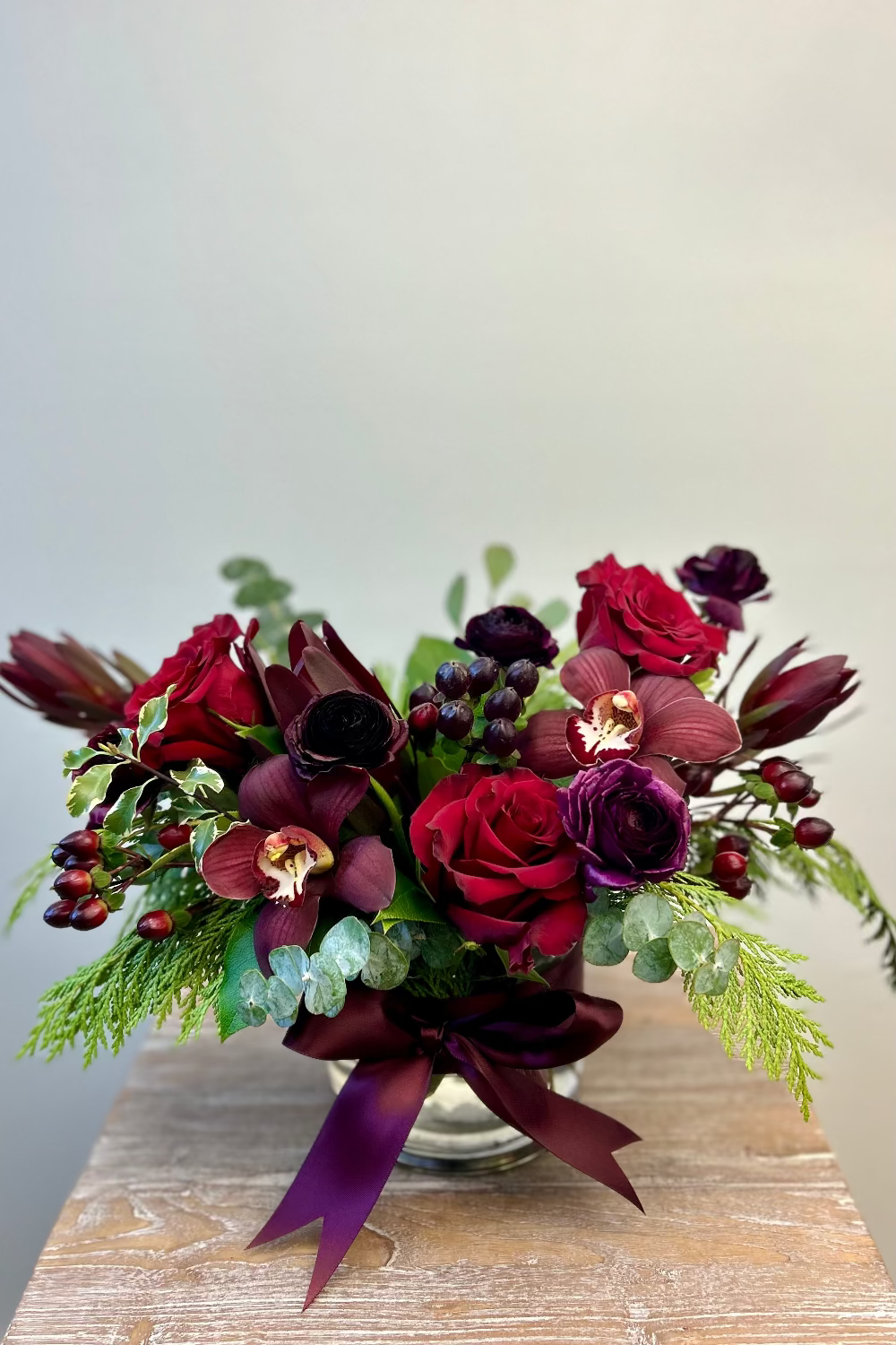 ugar Plum Dreams bouquet with plum and burgundy flowers and evergreens