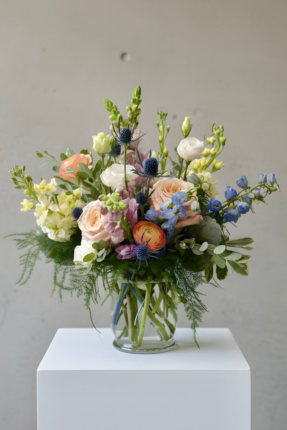Summer Sorbet pastel summer flower bouquet with stock, delphinium, snapdragons, lisianthus, ranunculus, and eucalyptus arranged in an airy, garden‑style design.