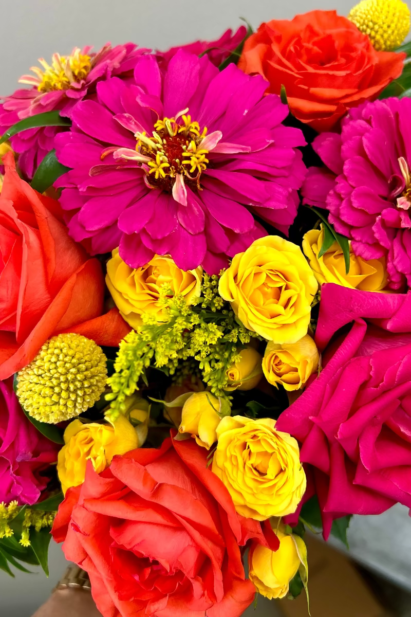 Close-up of Sunpop bouquet showing vibrant blooms and playful textures including billy balls and eucalyptus