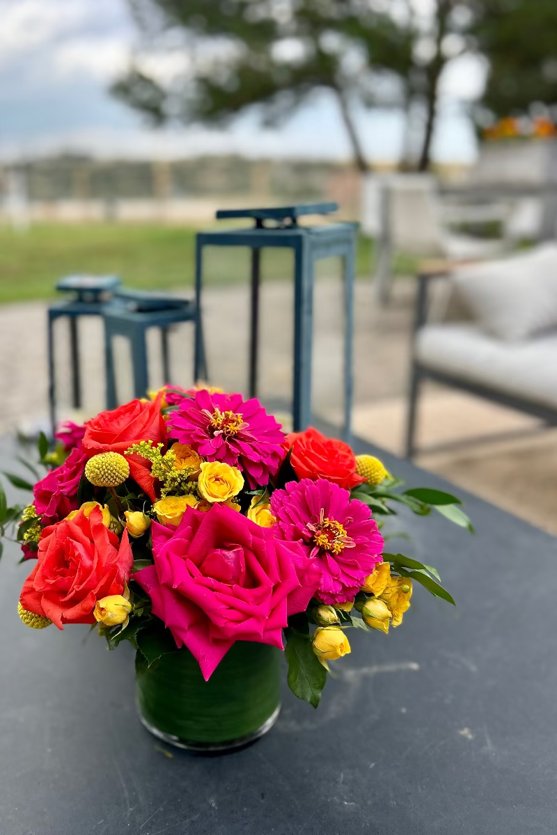 Sunpop signature bouquet displayed on an outdoor table with natural light highlighting bold colors and lush design