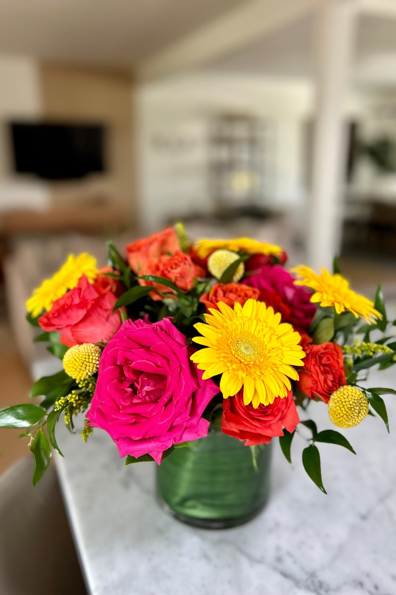 Close-up of Sunpop bouquet showing vibrant blooms and playful textures including billy balls and eucalyptus