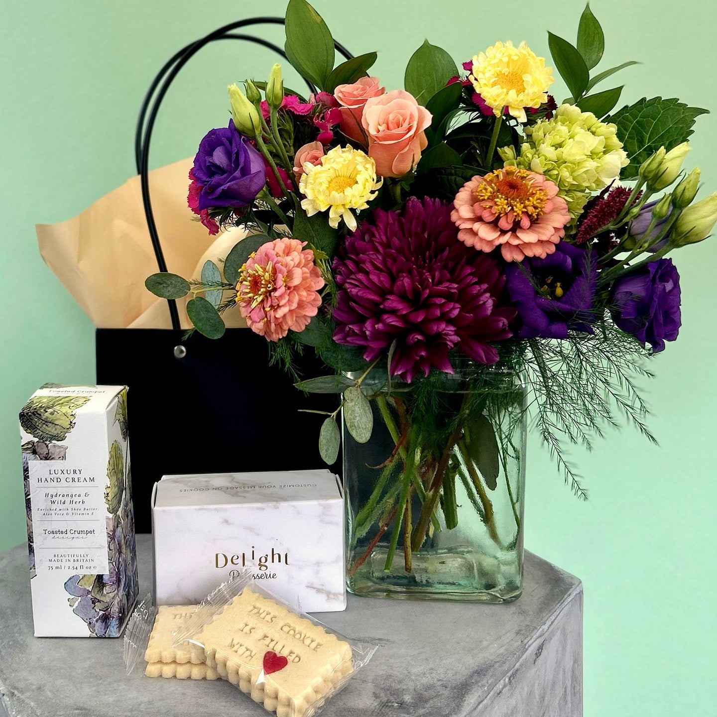 Bouquet of flowers in a vase with cookies and hand lotion perfect gift