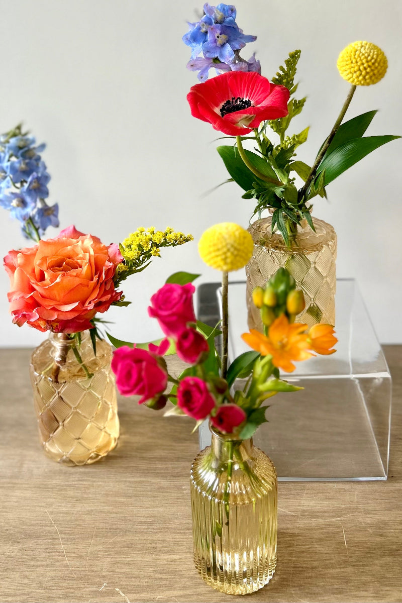 Three small glass vases with colorful summer seasonal flowers for home decor or summer parties in lone tree colorado 