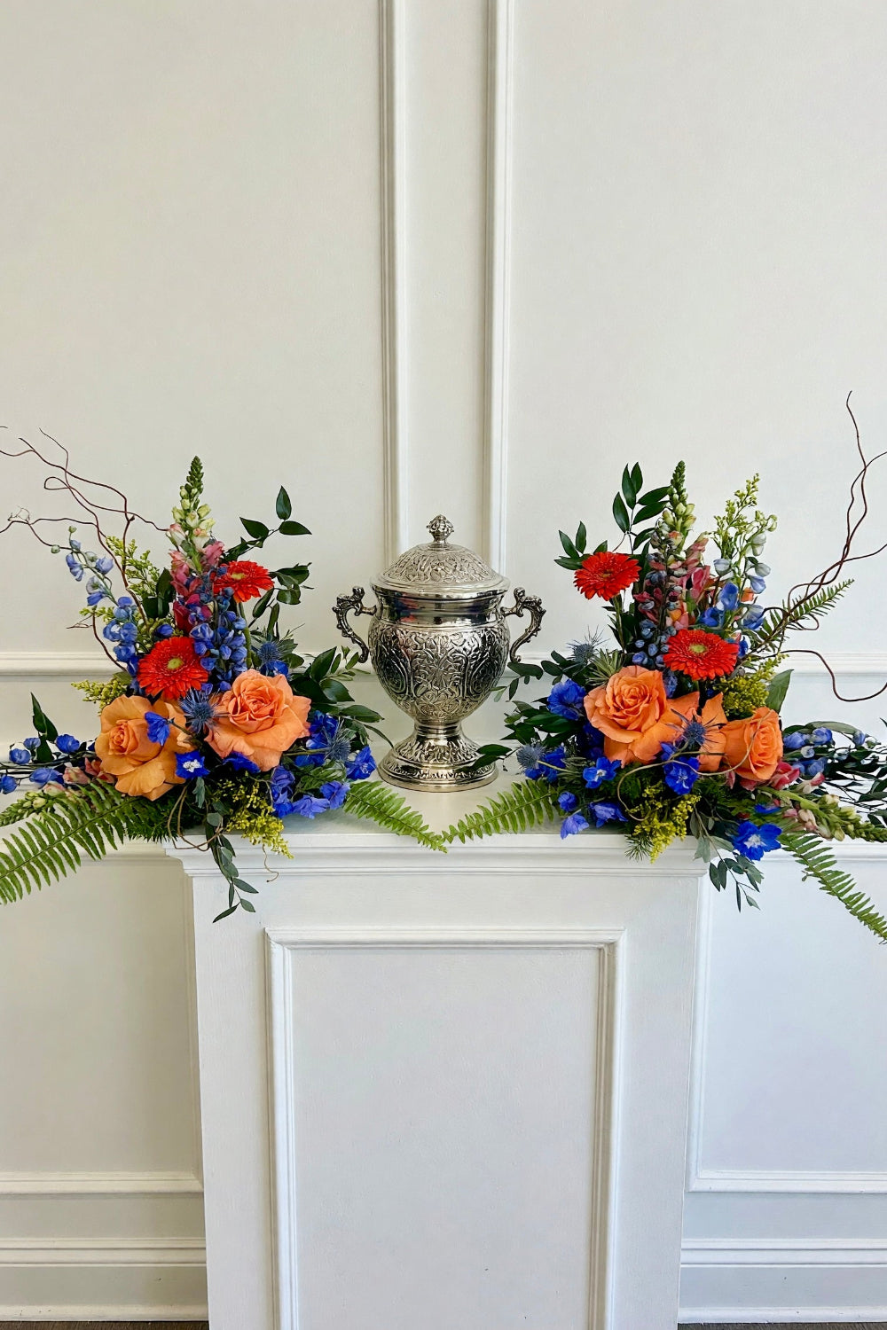 Funeral urn flower frame with elegant memorial flowers arranged around an urn, designed by The Flower Fix.