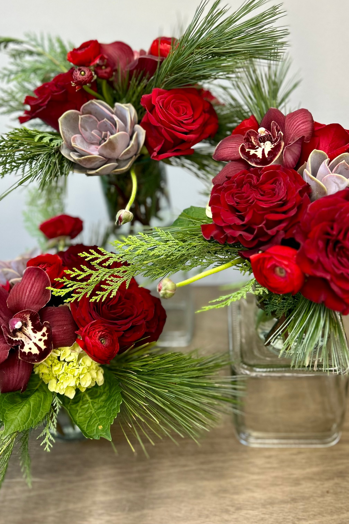 red bouquets with roses succulents evergreens