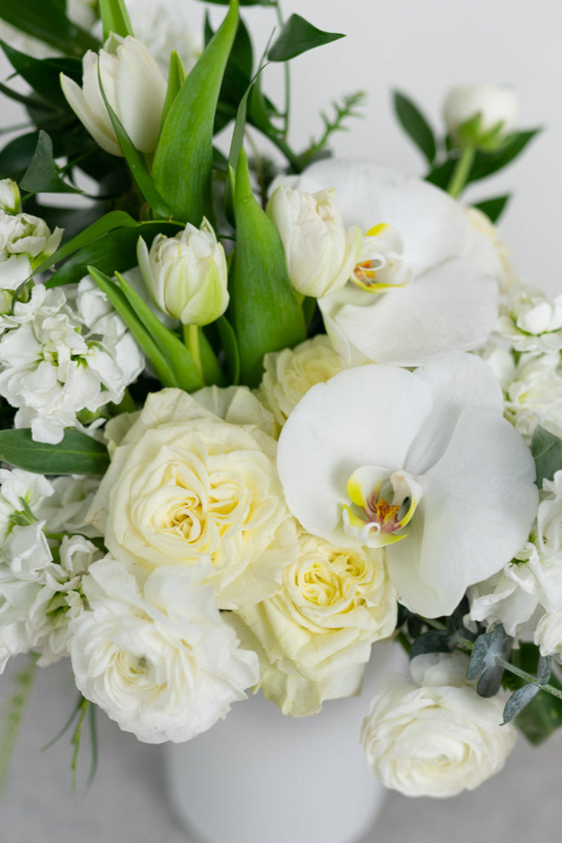 white flower bouquet of orchids roses stock ranunculus for loss comfort