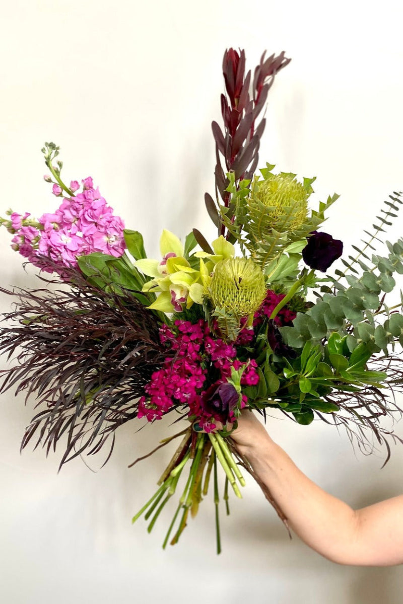 hand tied bunch of fun summer flowers being held